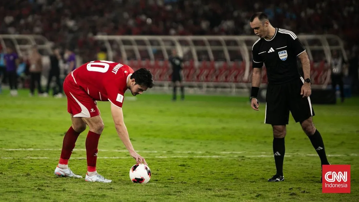Football on the penalty spot facing a goal on a stadium pitch