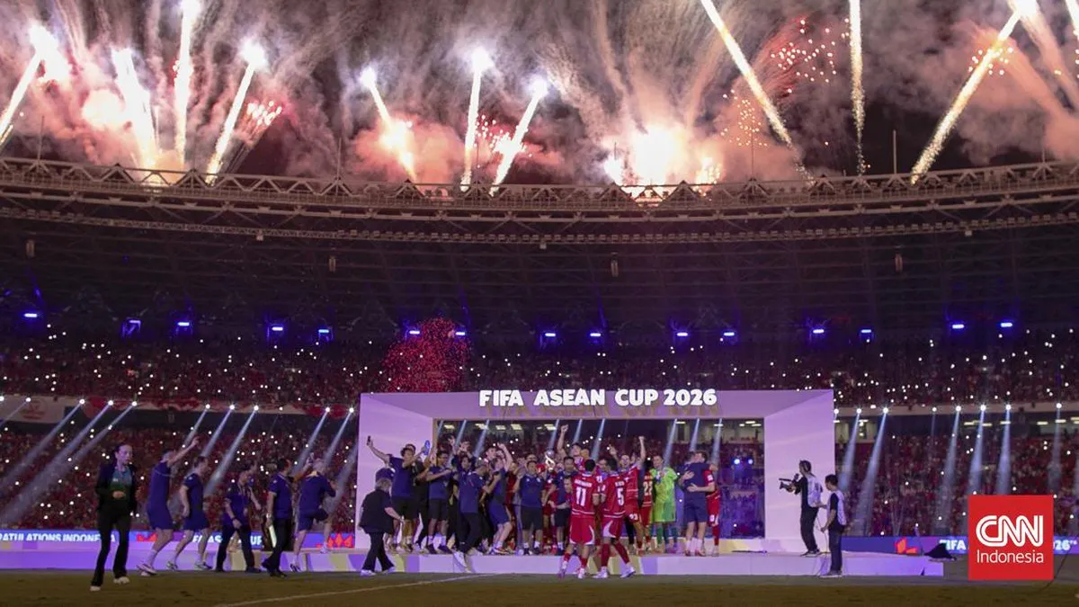 Football on a pitch beside a trophy